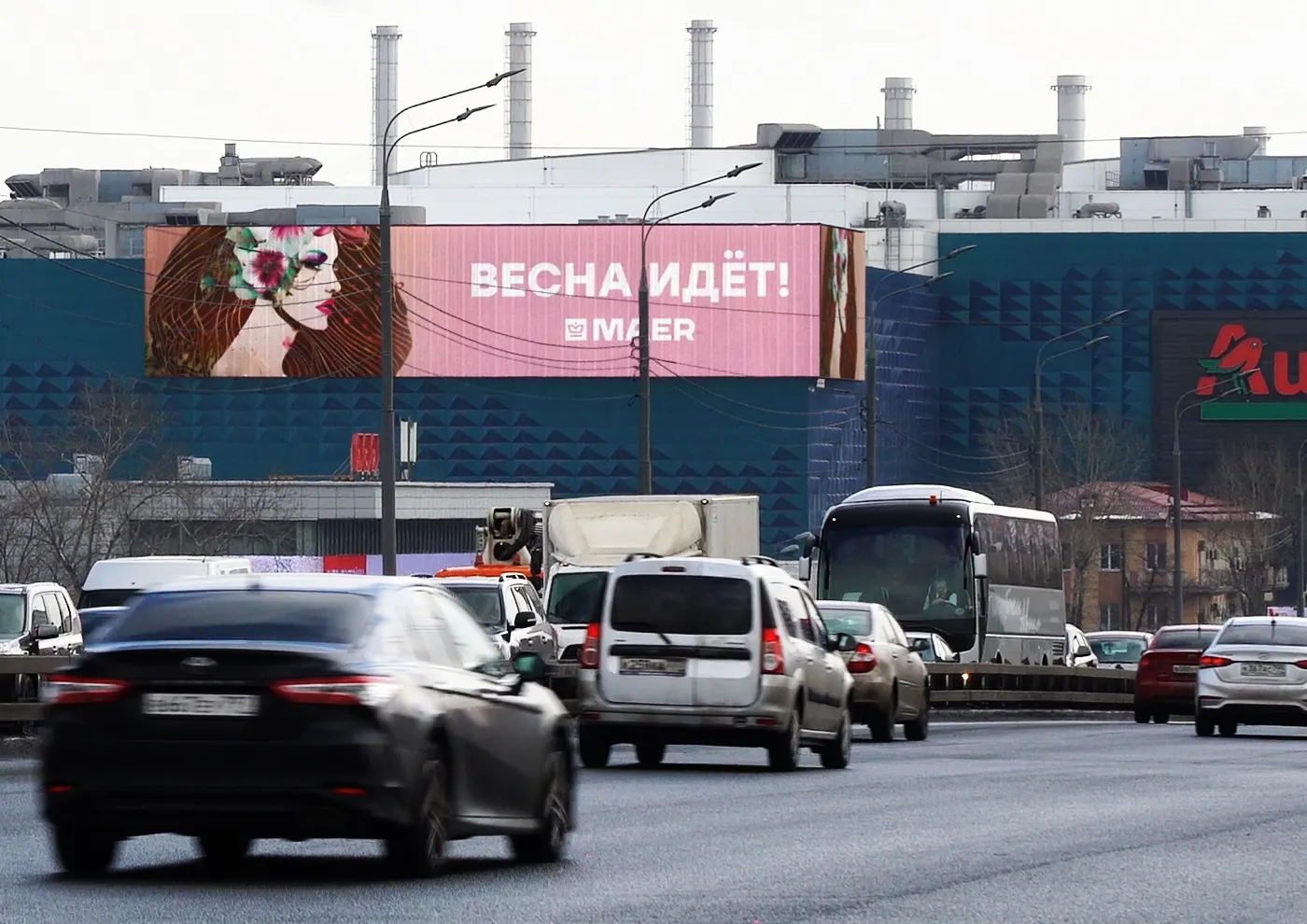 Широкий билборд с весенней кампанией на фасаде здания