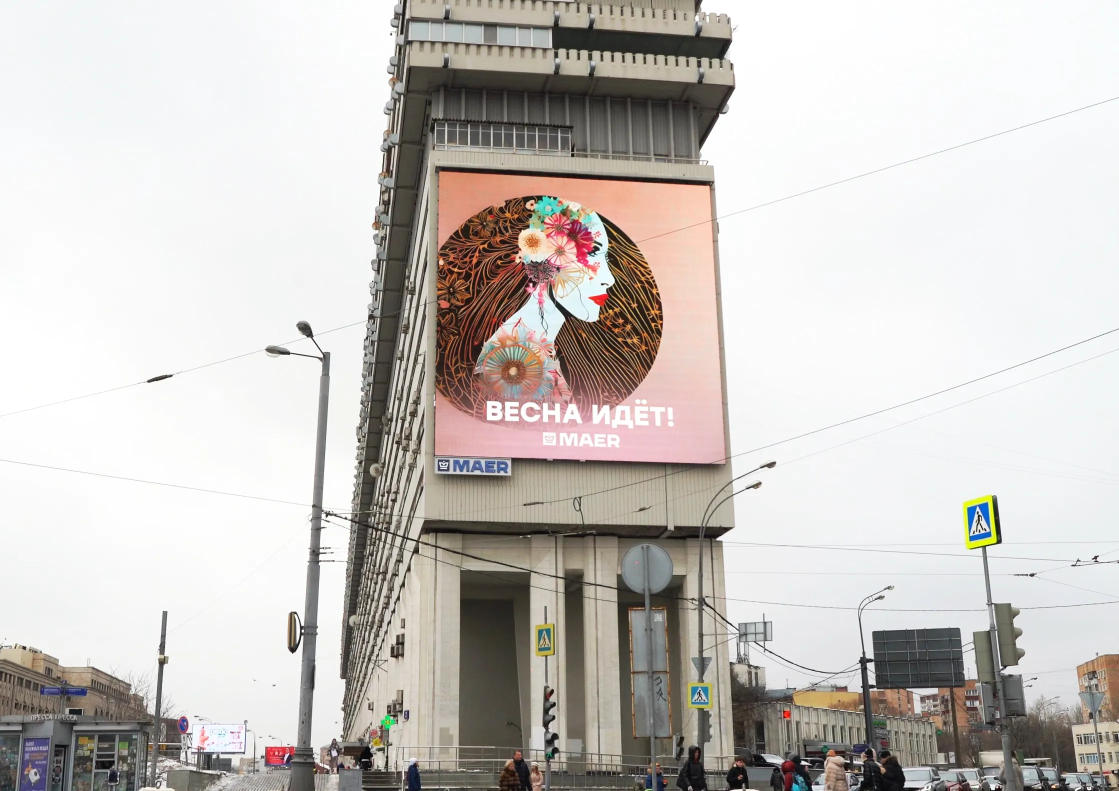 Вертикальный экран с весенней рекламой на фасаде башни