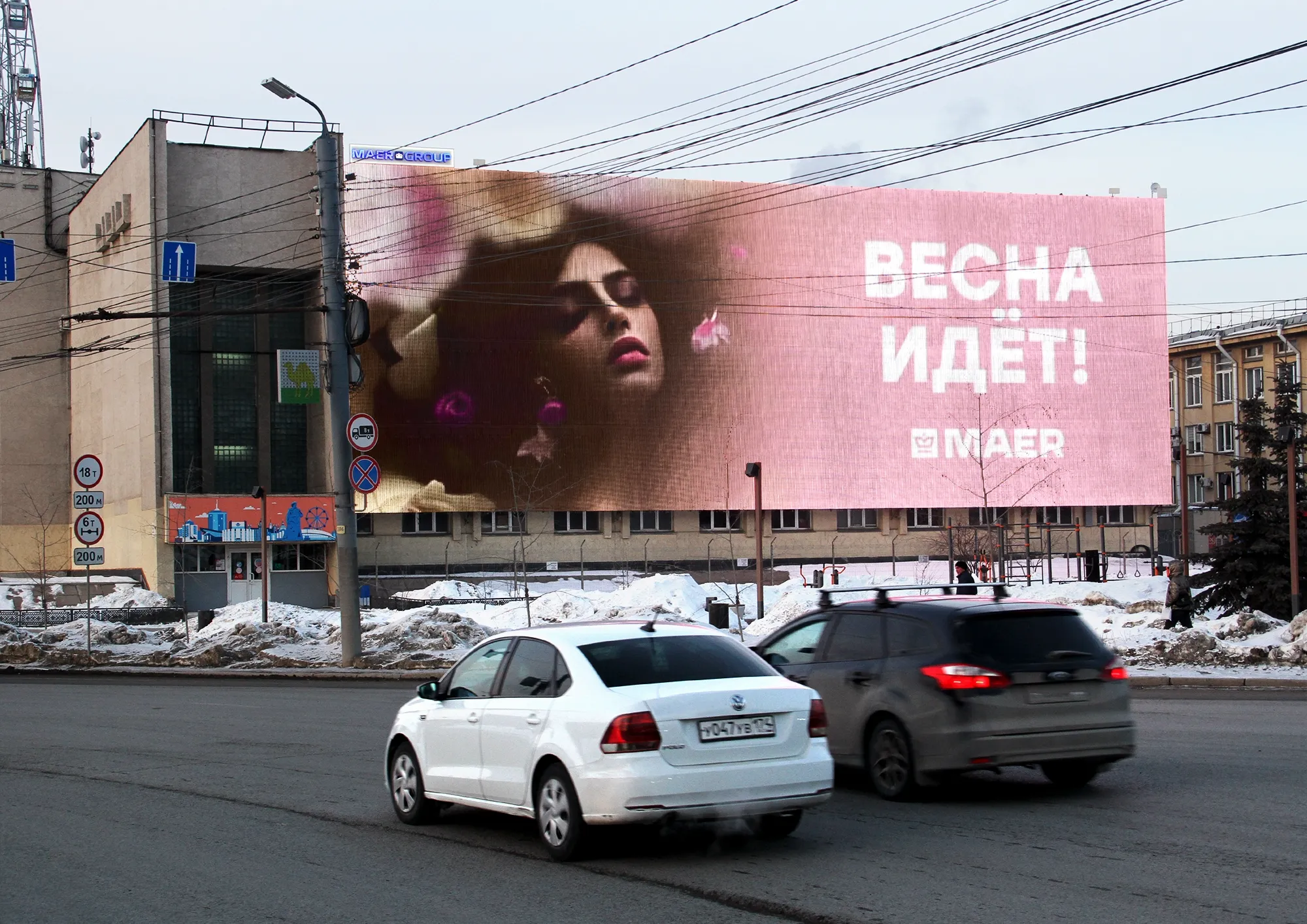 Городской экран с весенней кампанией MAER над автомобильным потоком