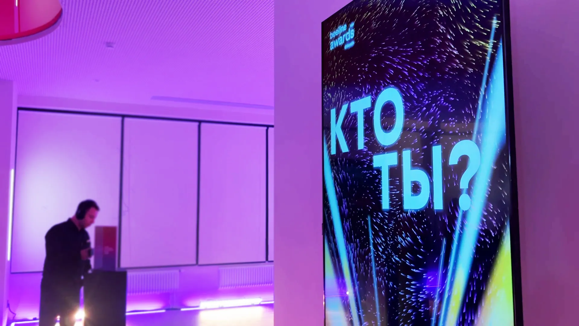 Гость работает с вертикальным экраном в зале с фиолетовой подсветкой