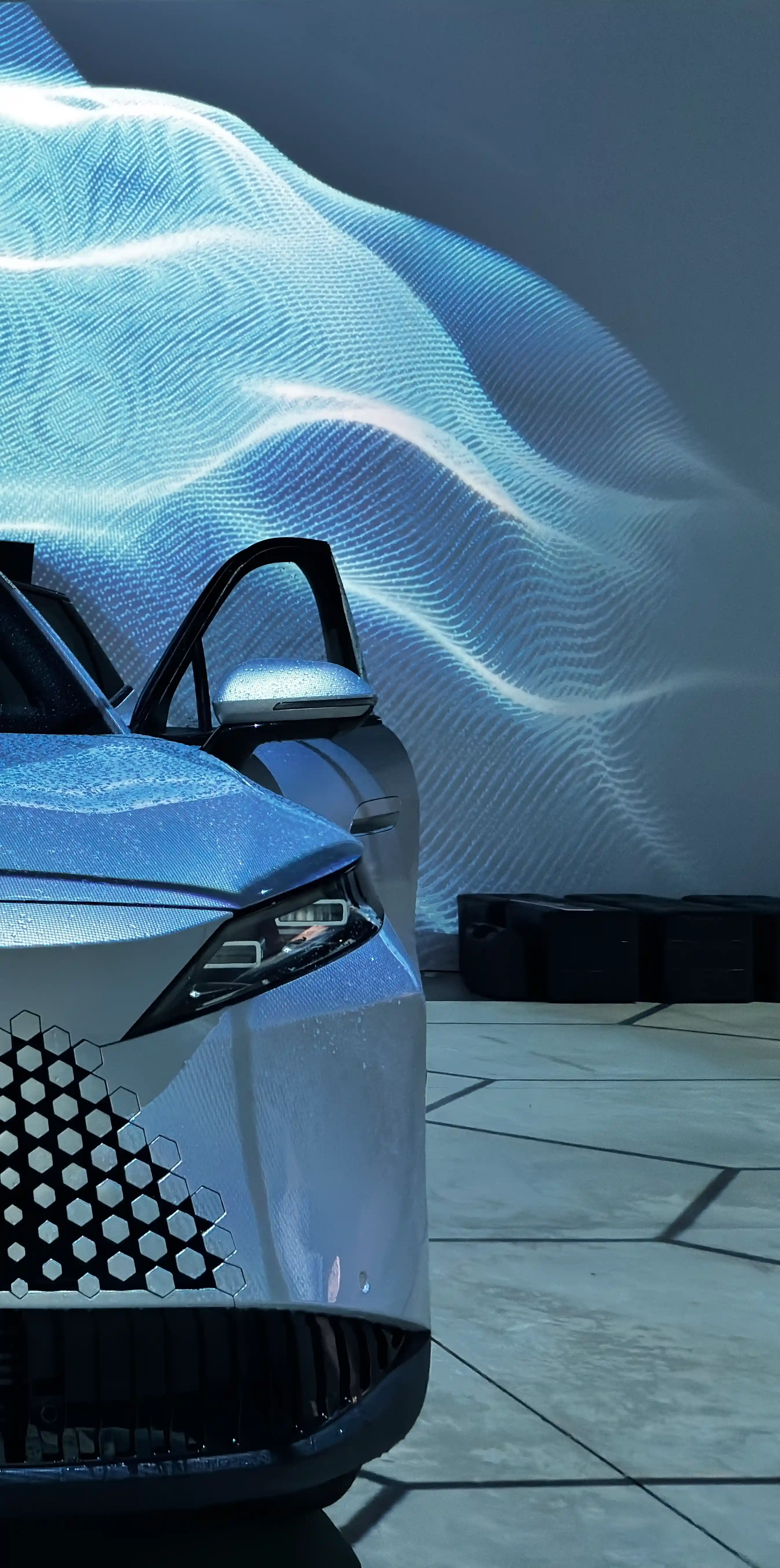 Крупный план автомобиля OMODA C7 на фоне световой проекции